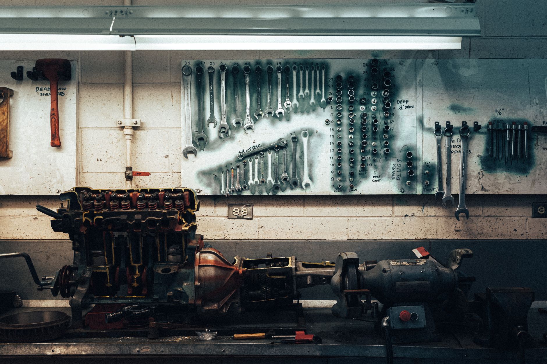 Wrenches hanging on a workshop wall above a workbench