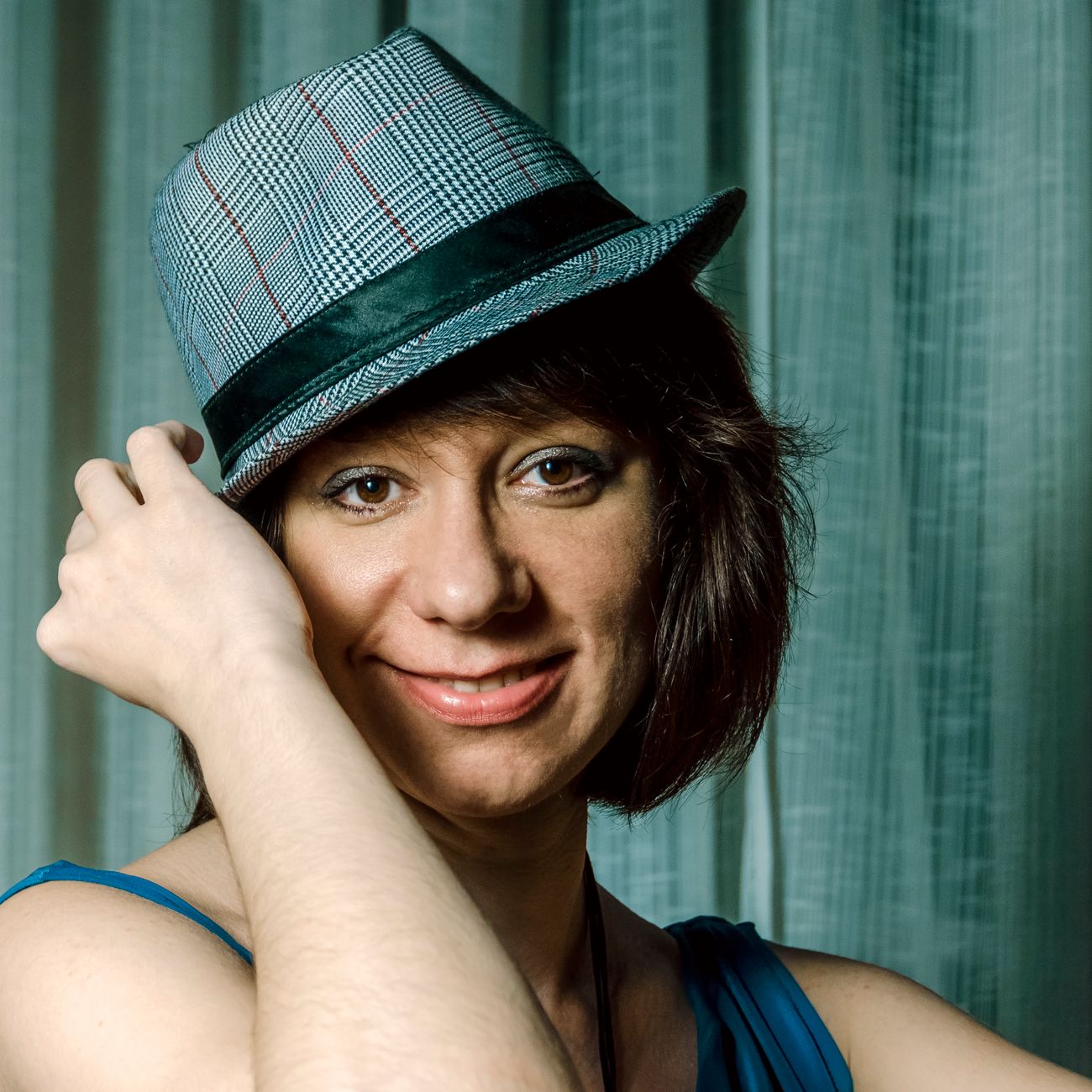 Portrait of a smiling woman in a blue fedora
